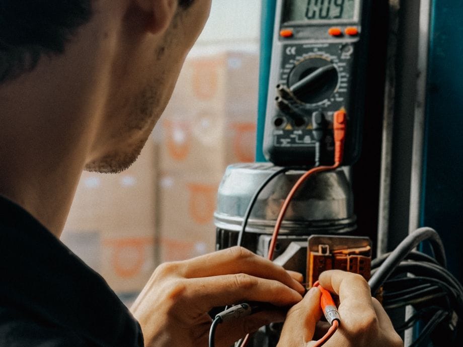 Qualified electrician inspecting and testing fixed wiring for an EICR