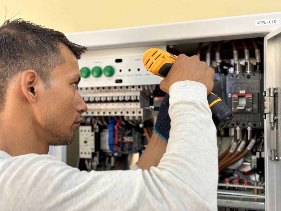 Electrician fitting a modern metal consumer unit with RCBO protection