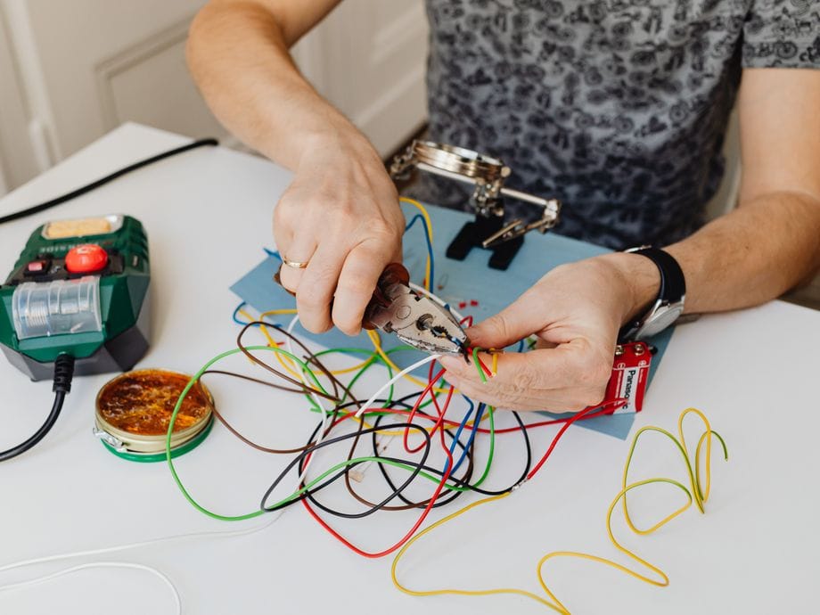 Electrician preparing new colour-coded cabling during a house rewire
